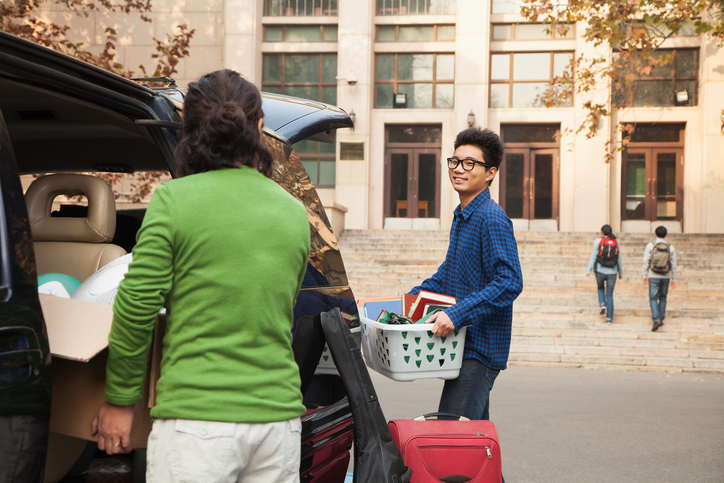 A young man moving into a residence hall.